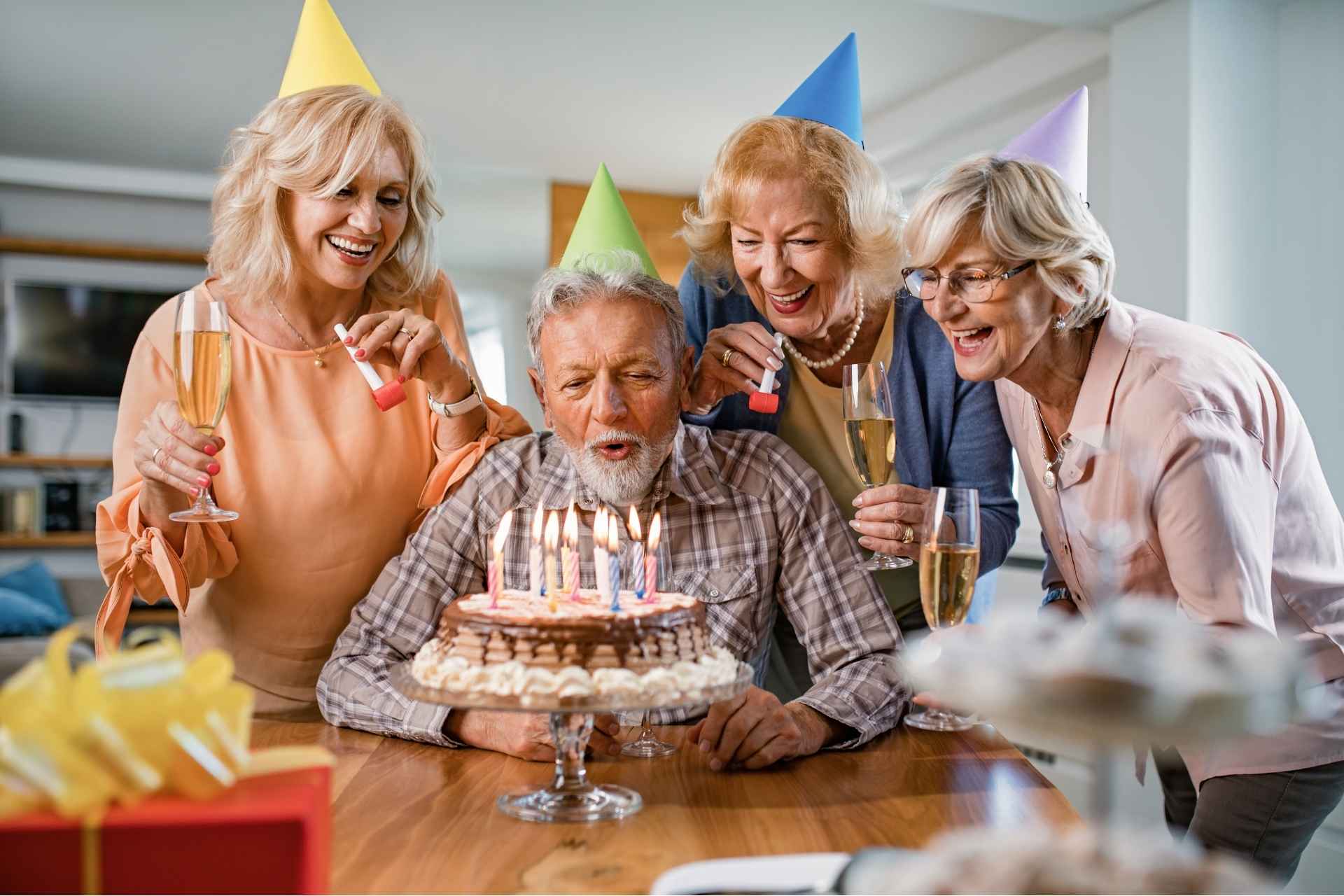 group gathers around a senior man celebrating his birthday