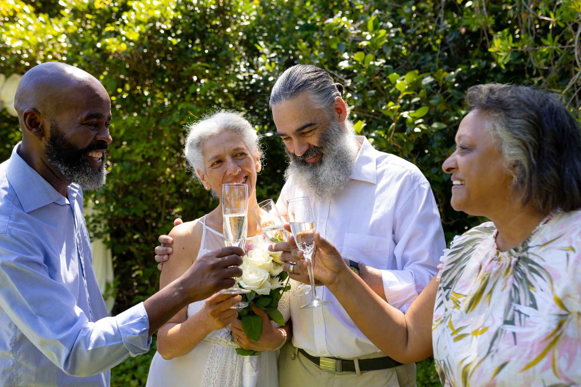 A group of seniors standing together outside toasting glasses.